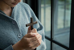 Asian woman hold the cross with belief in Jesus Christ., religion and worship concept.