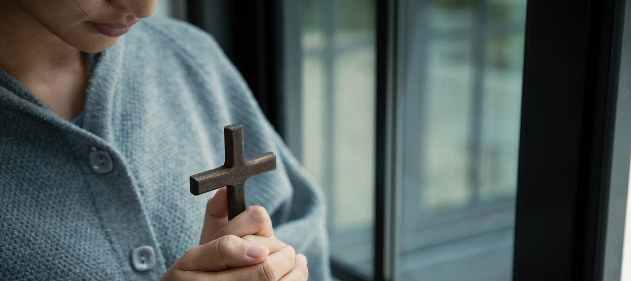 Asian woman hold the cross with belief in Jesus Christ., religion and worship concept.