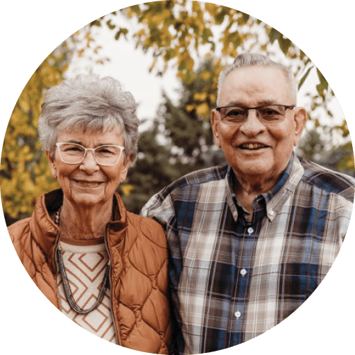 A man and woman standing in front of a tree. Description generated by AI