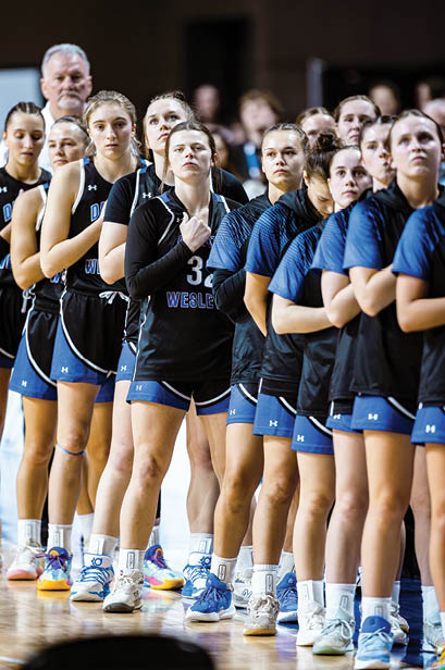 A group of women wearing black and blue uniforms. Description generated by AI