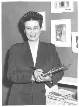 A woman in a suit holding a pen. Description generated by AI