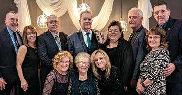 A group of people sitting together for a picture. Description generated by AI
