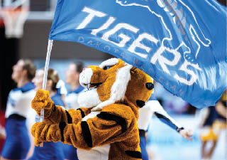 A person holding a blue and white flag with a tiger on it. Description generated by AI