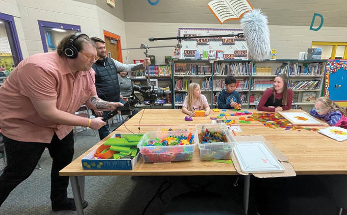 A group of children are playing with toys in a library. Description generated by AI