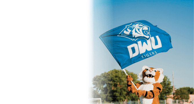 A person holding a blue and white flag with a tiger mascot on it. Description generated by AI